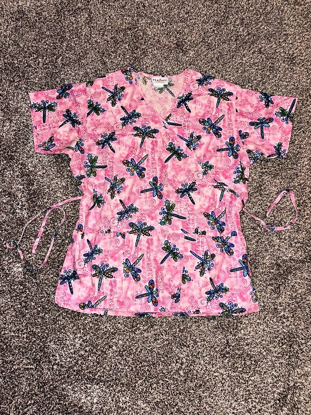 Pink whimsical babydoll style scrub top with dragonfly design